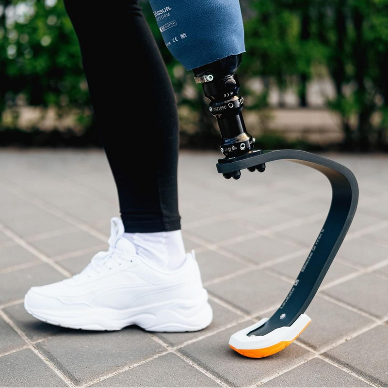 Levitate prosthetic blade worn on a city street alongside a natural foot