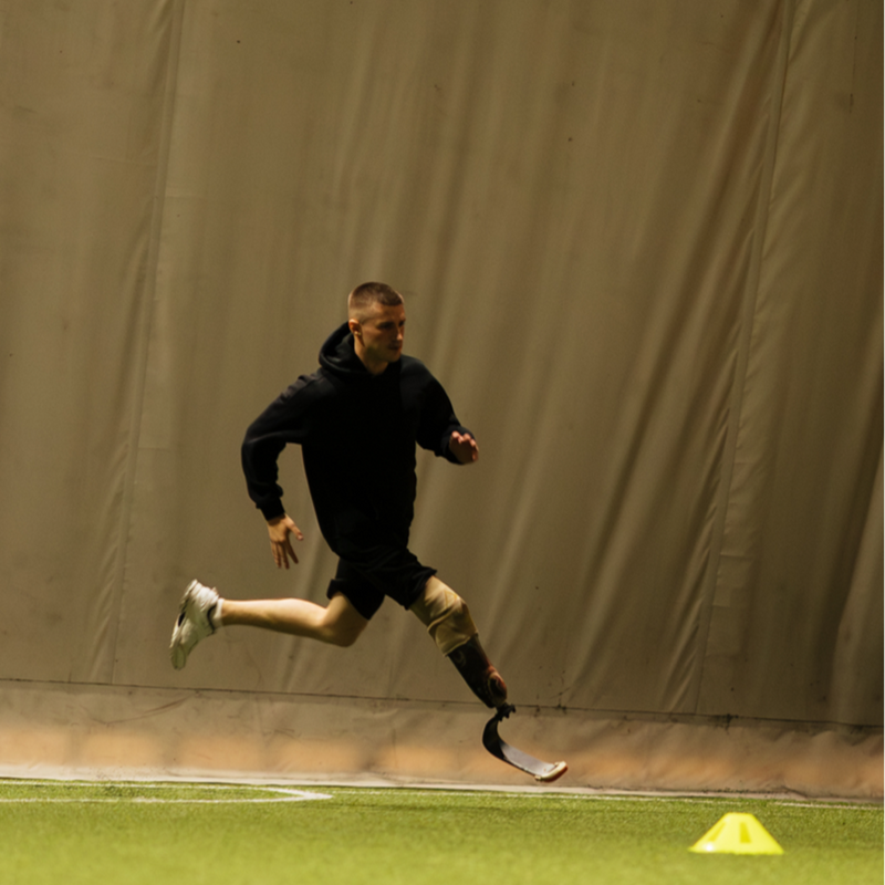 Athlete running with Levitate prosthetic blade